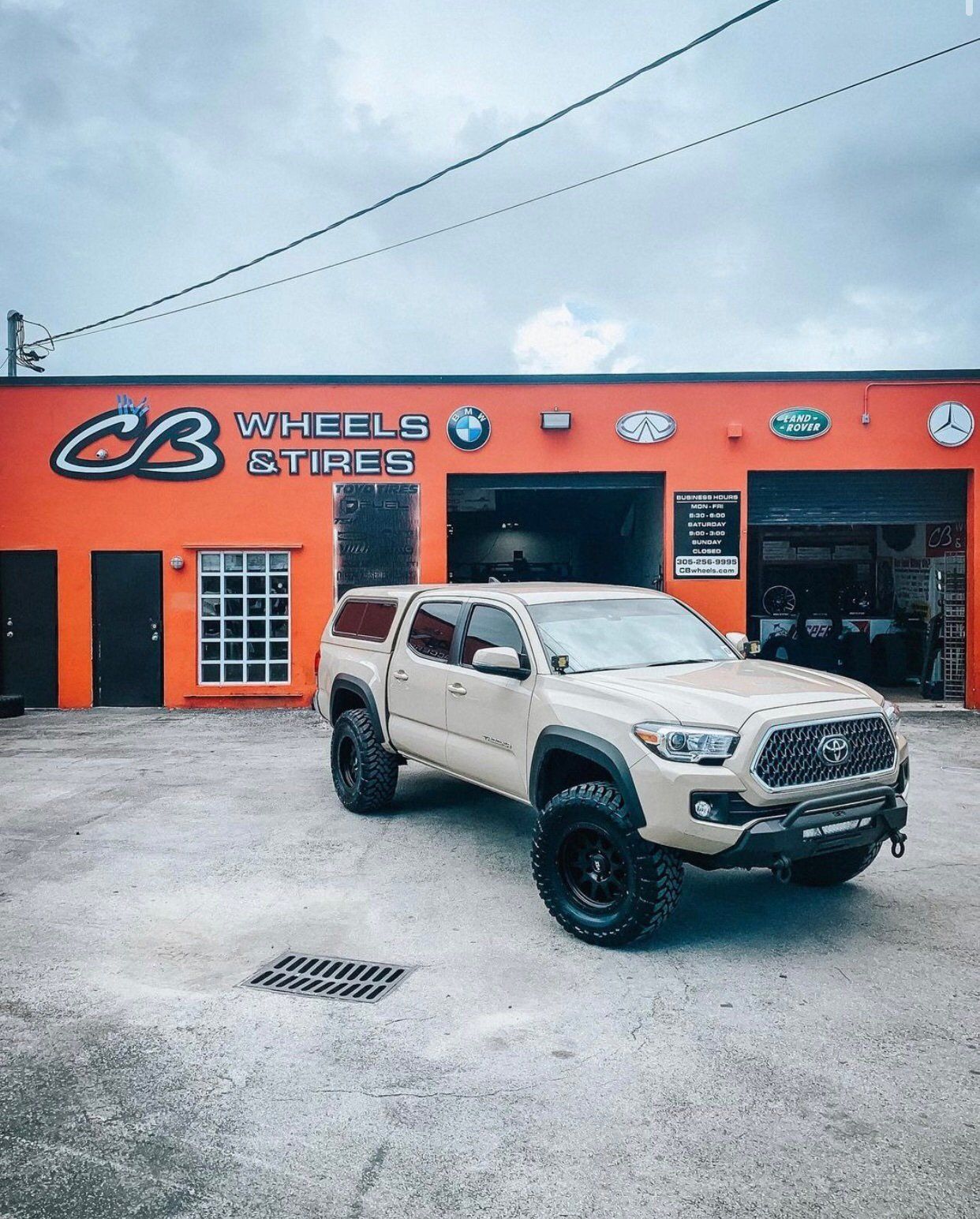 A truck is parked in front of a wheels and tires store. | CB Wheels & Tires, 4x4, Suspension, Center