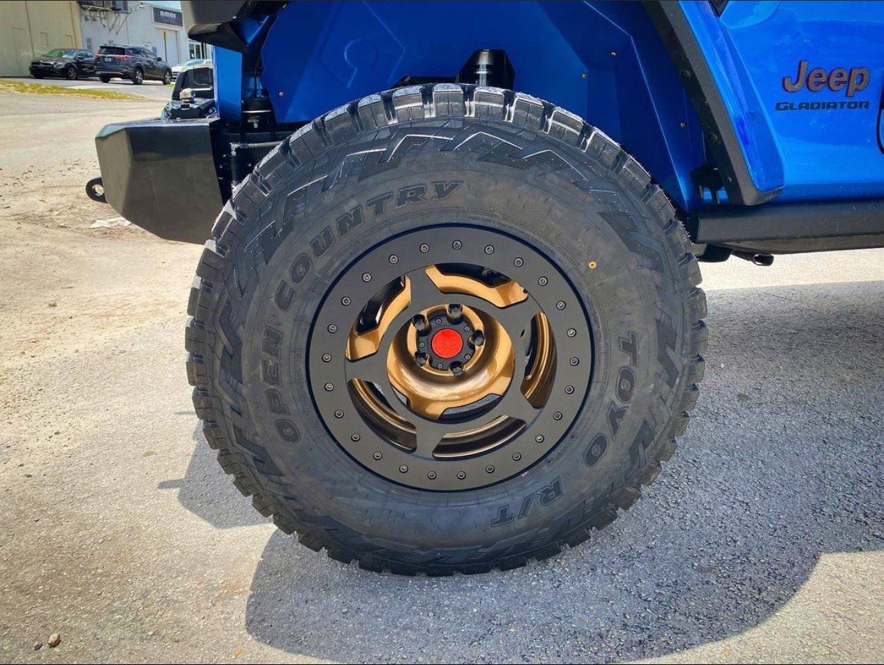 A close up of a tire on a blue jeep. | CB Wheels & Tires, 4x4, Suspension, Center