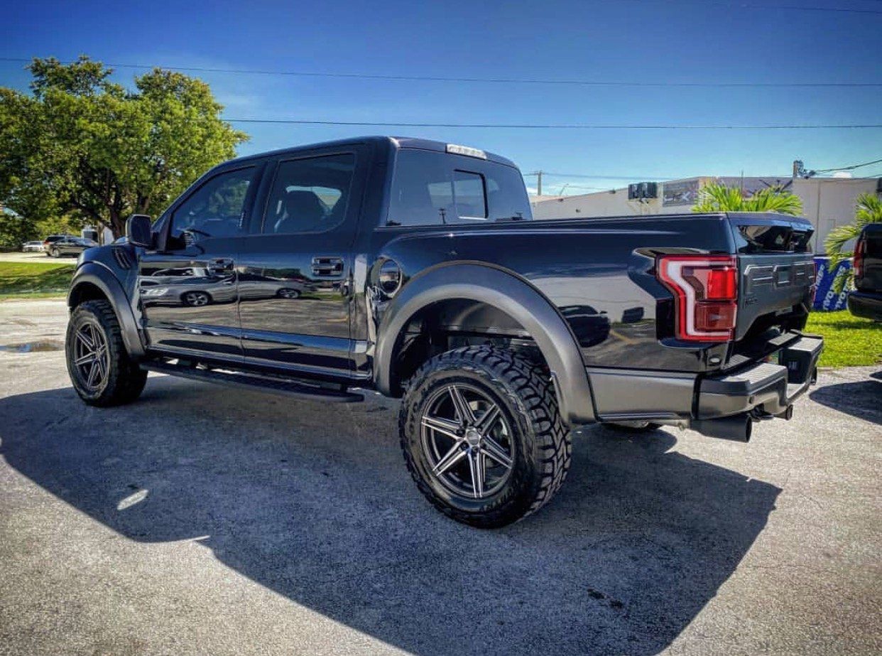 A black ford raptor is parked in a parking lot. | CB Wheels & Tires, 4x4, Suspension, Center