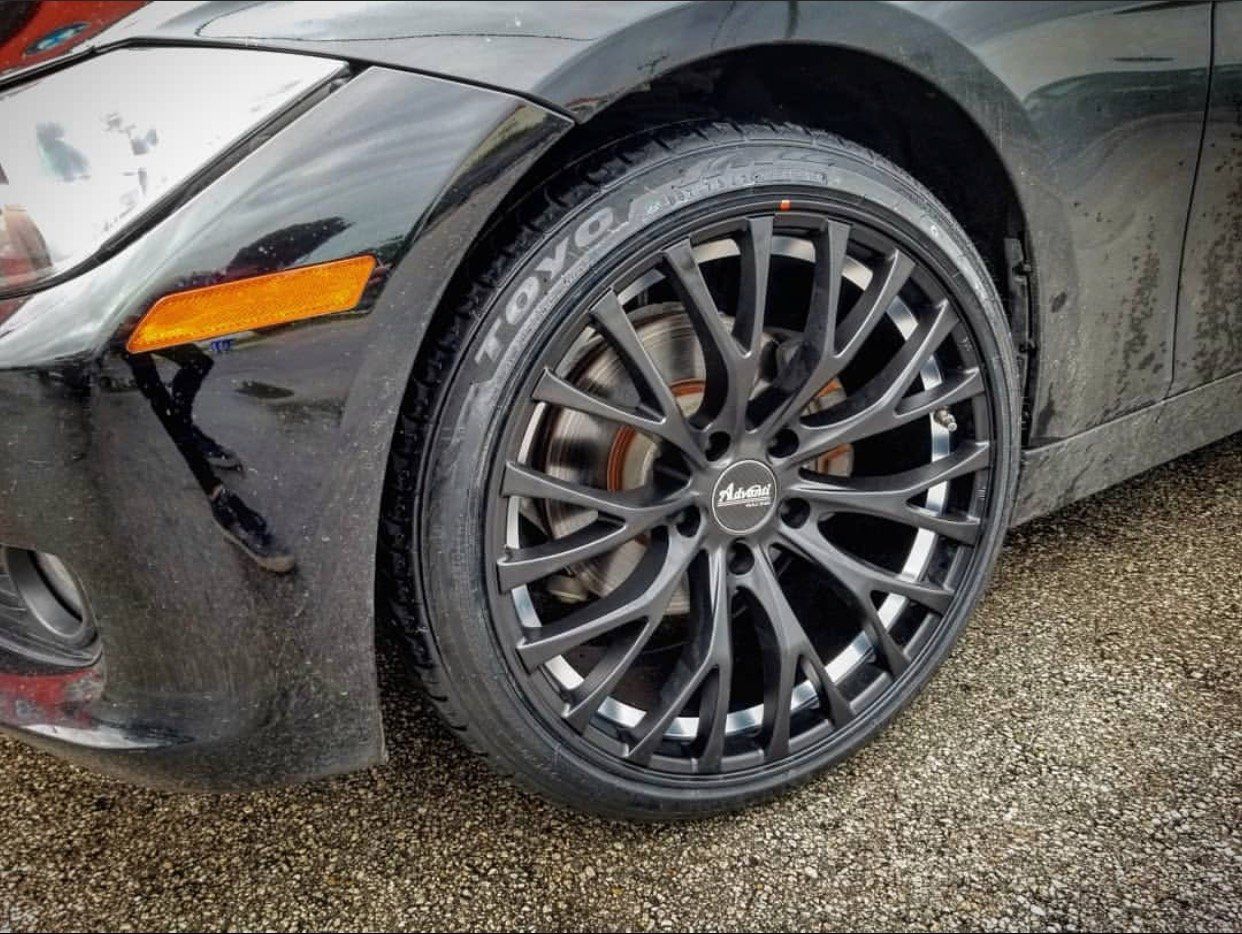A close up of a black car 's tire on a gravel road. | CB Wheels & Tires, 4x4, Suspension, Center