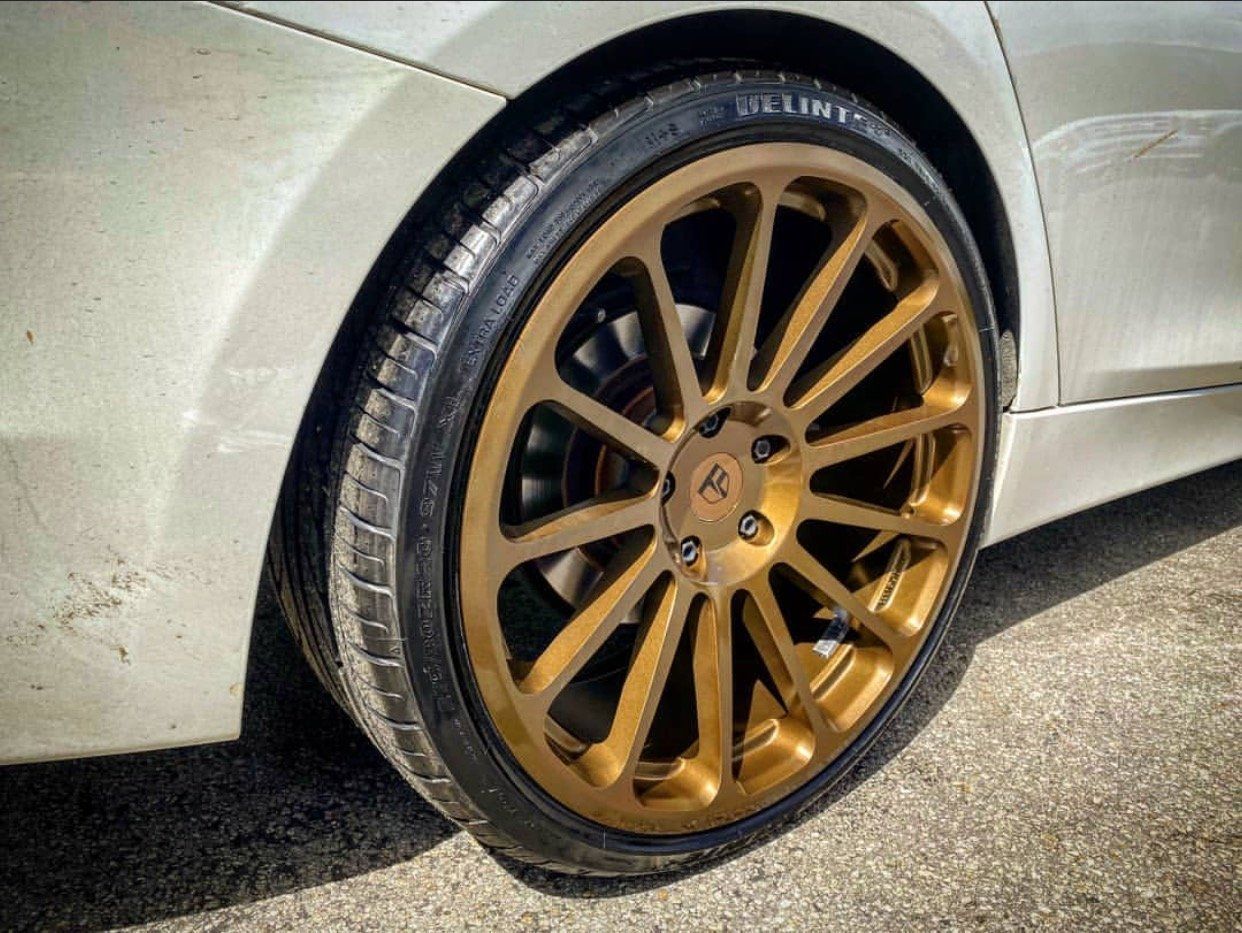 A white car with gold wheels and tires is parked on the side of the road. | CB Wheels & Tires, 4x4, Suspension, Center