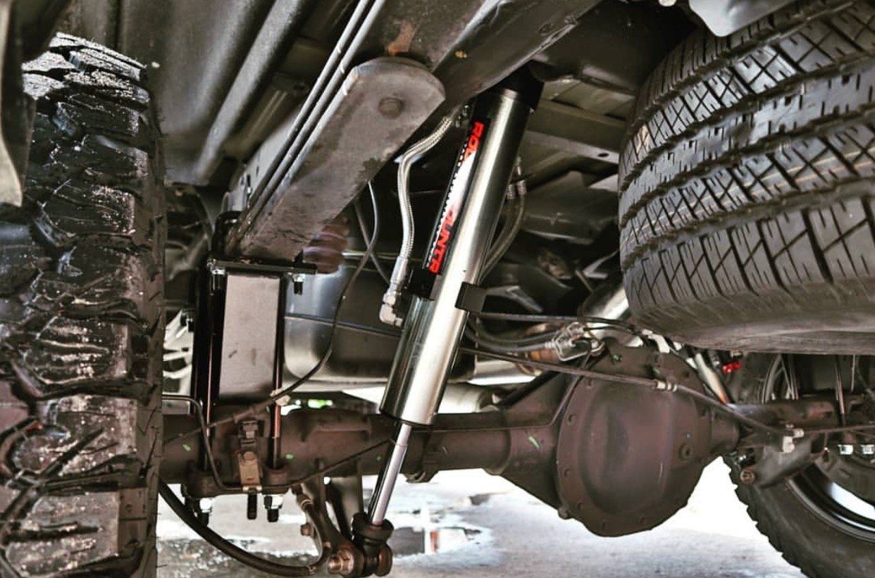 A close up of the underside of a truck with a shock absorber and tires. | CB Wheels & Tires, 4x4, Suspension, Center