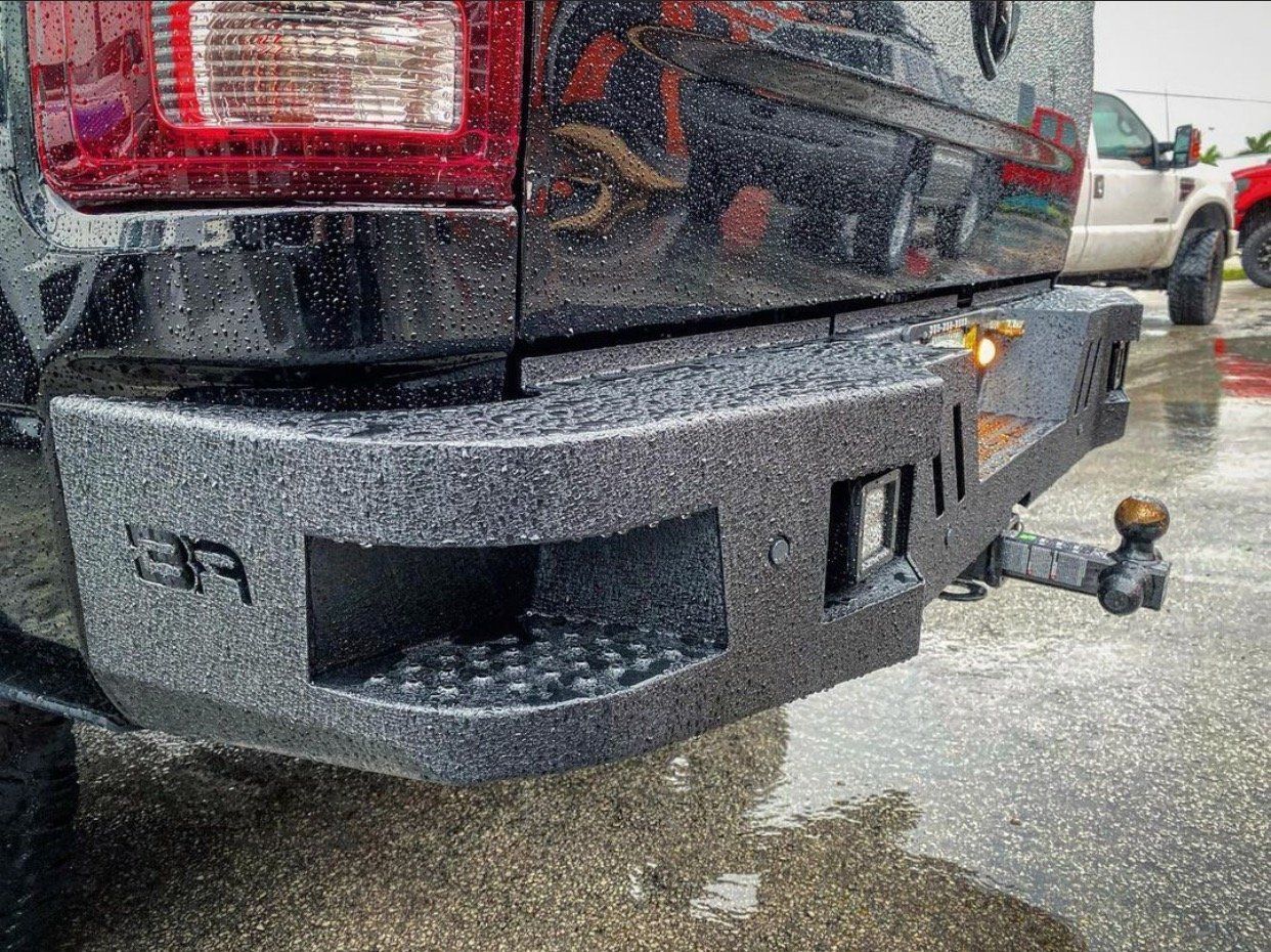 A black truck is parked in the rain on a wet road. | CB Wheels & Tires, 4x4, Suspension, Center