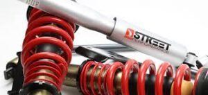 A close up of a pair of red shock absorbers on a white surface.