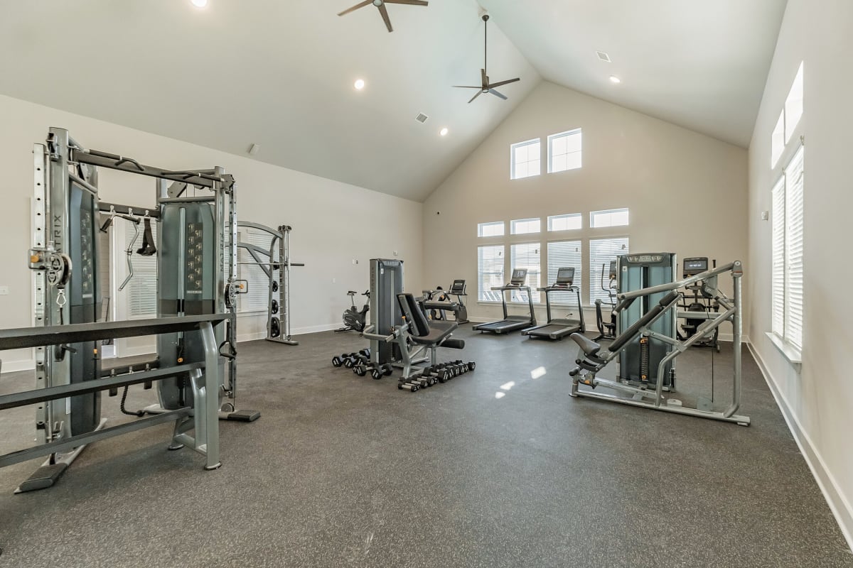 A large gym with a lot of equipment and a vaulted ceiling at The Standard at Pinestone. 