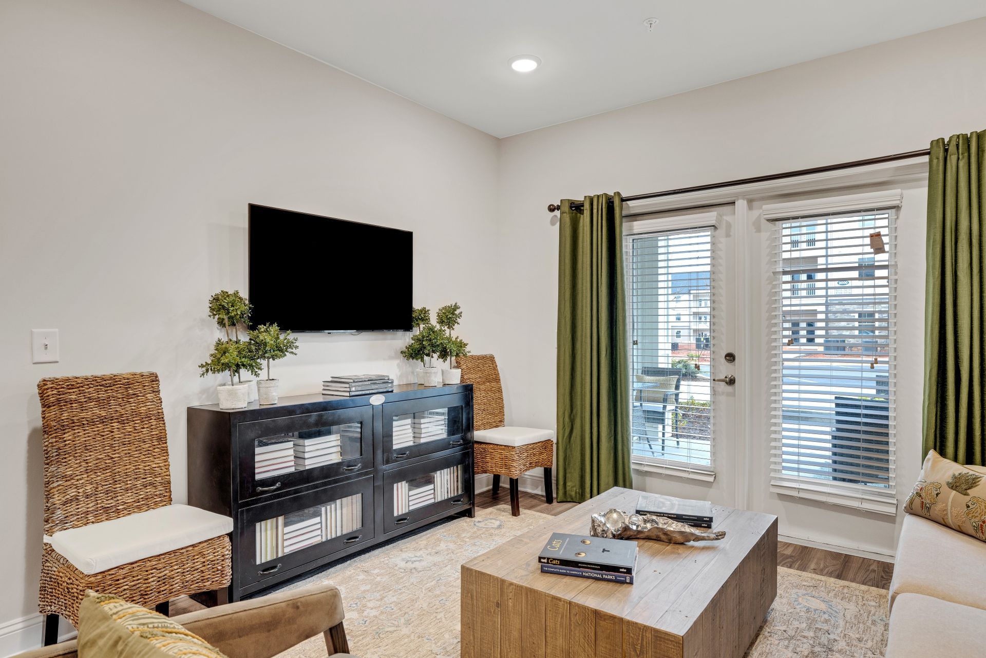 A living room with a couch , chairs , a coffee table and a flat screen tv at The Standard at Pinestone. 