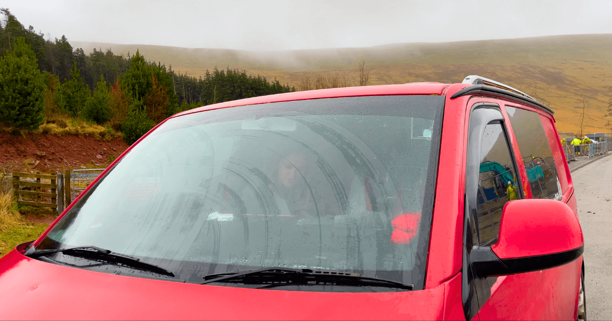 A red van is parked on the side of the road.