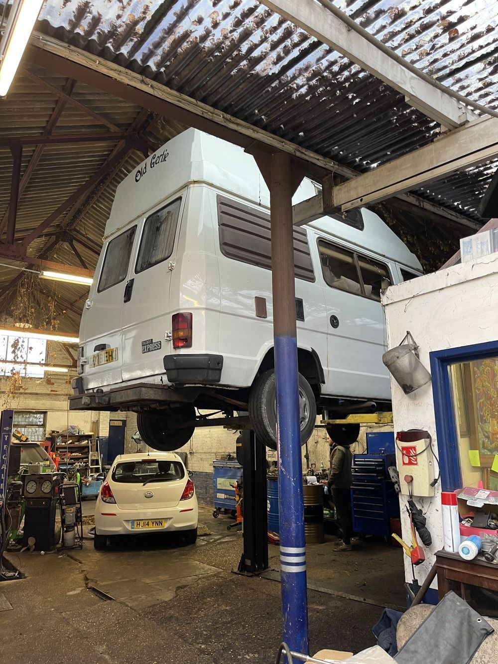 a white van is sitting on a lift in a garage .