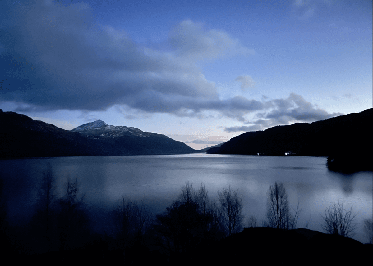 Loch Lomond with mountains in the background and clouds in the sky