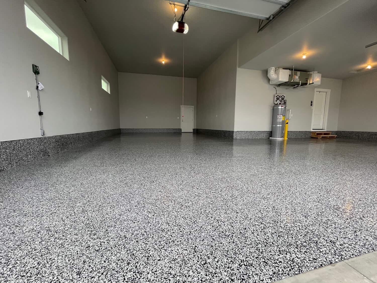 A garage with a gray floor and a garage door opener.