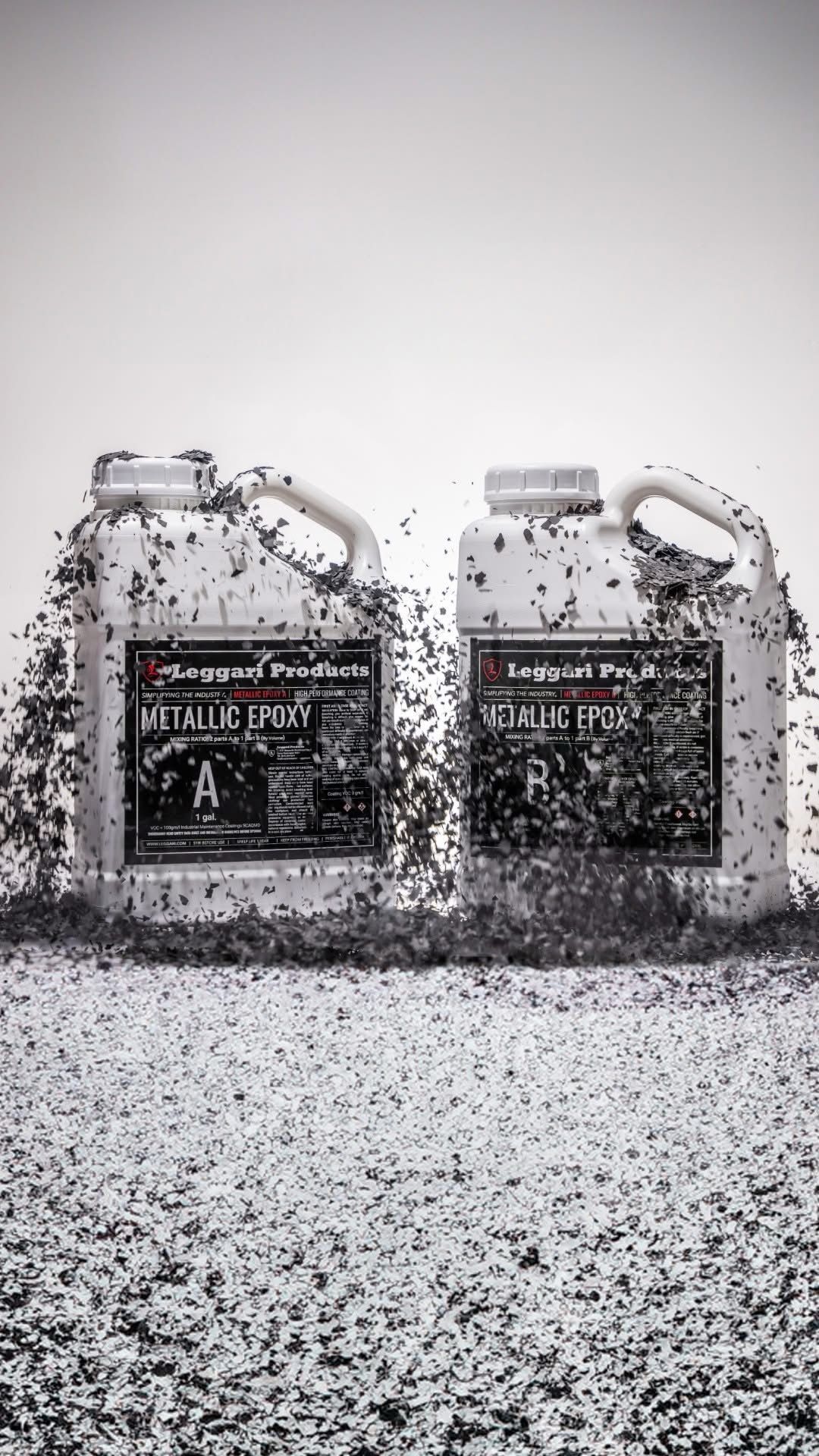 Two bottles of epoxy resin are sitting on top of a pile of gravel.