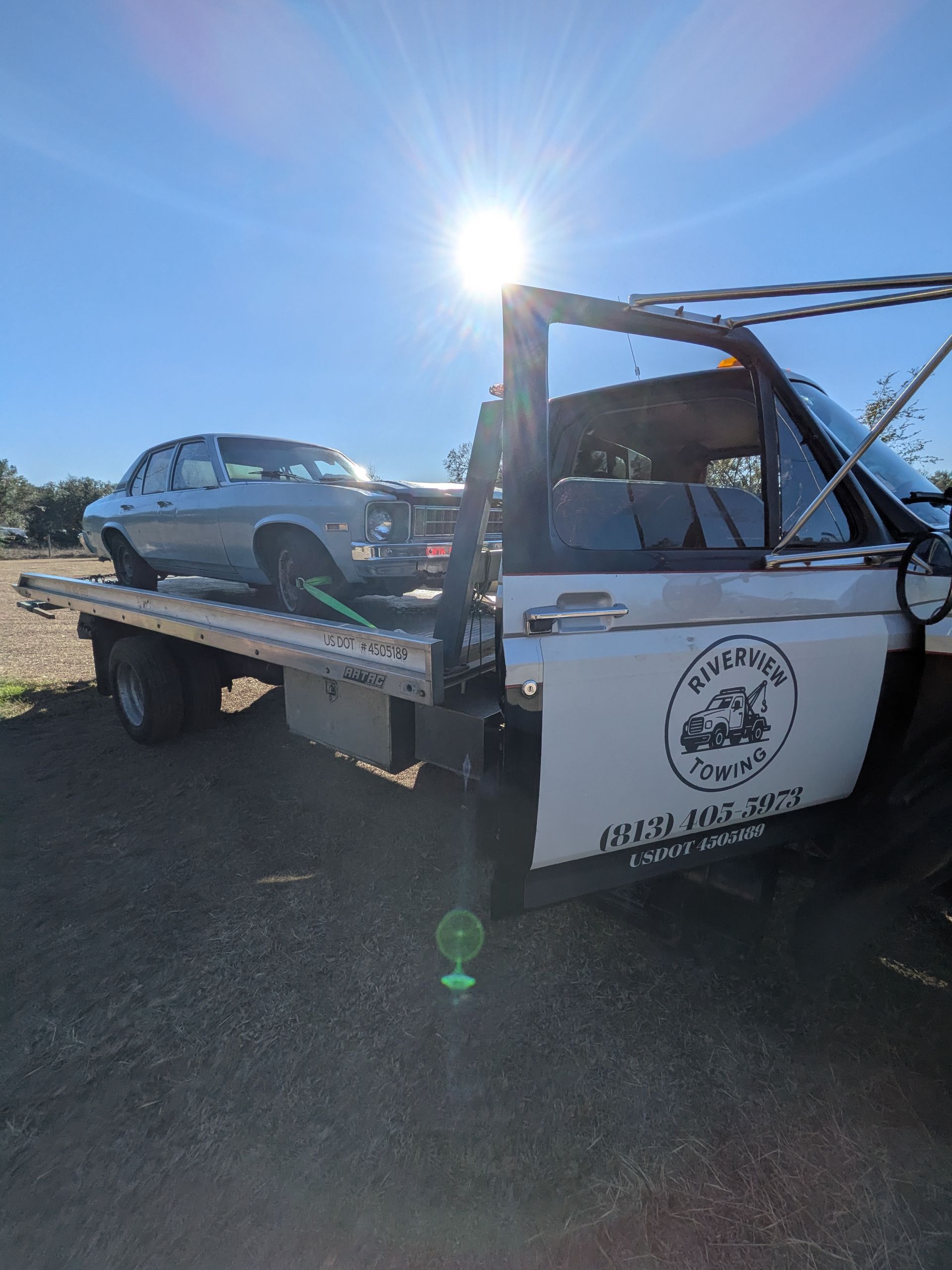 Riverview Towing safely transports a classic sedan on a secure flatbed rollback in Riverview, FL.