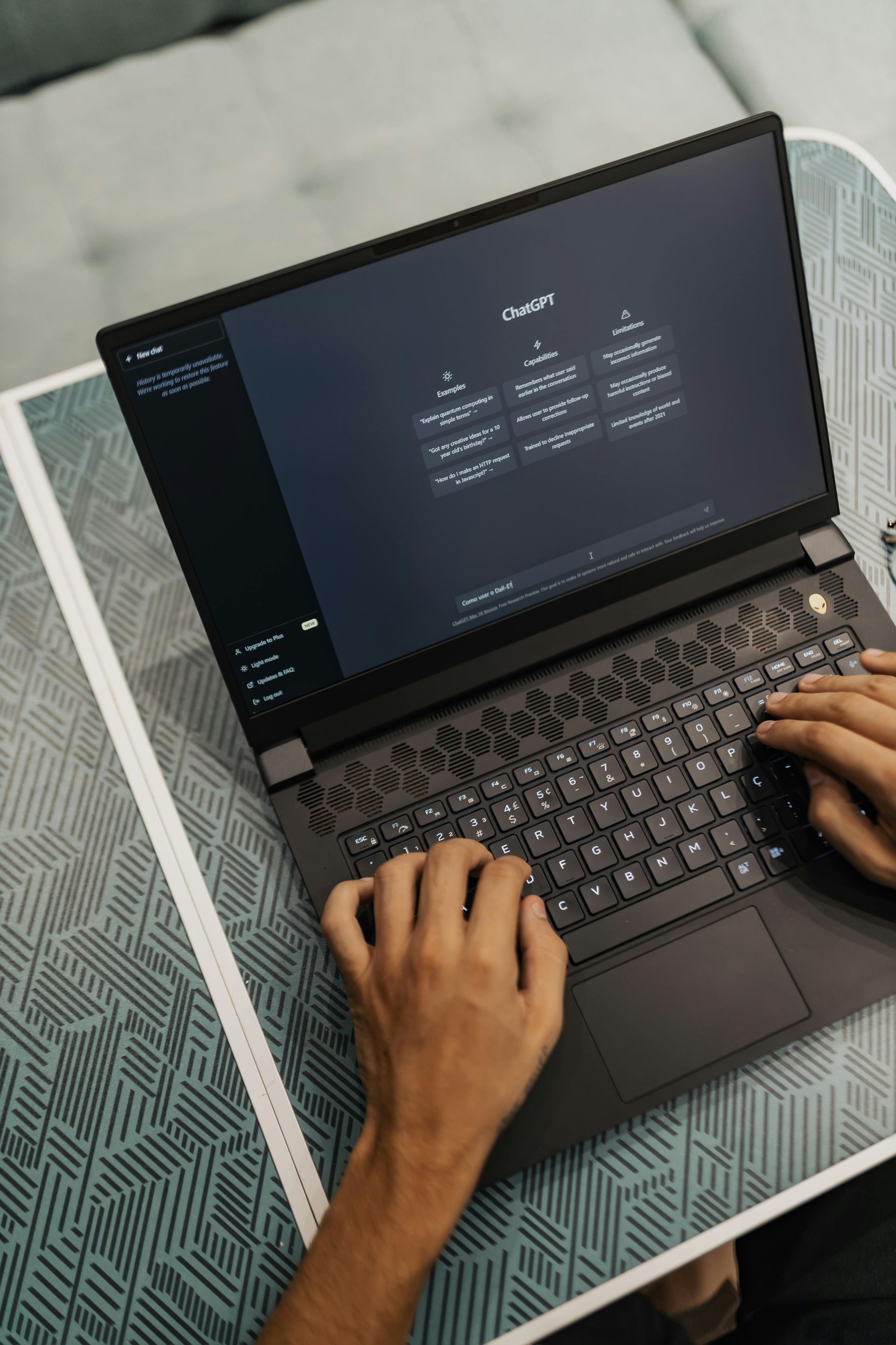 A person is typing on a laptop computer on a table.