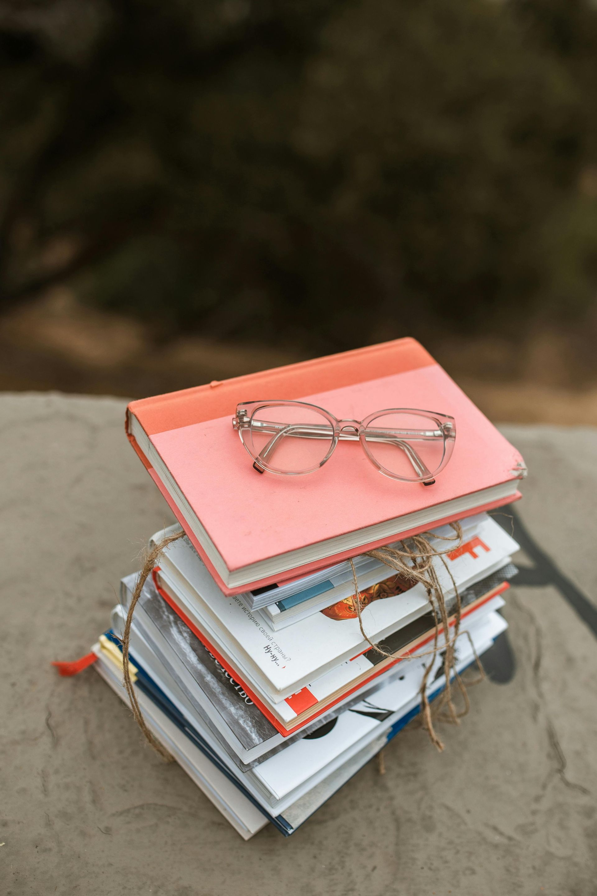 A stack of books with glasses on top of them.