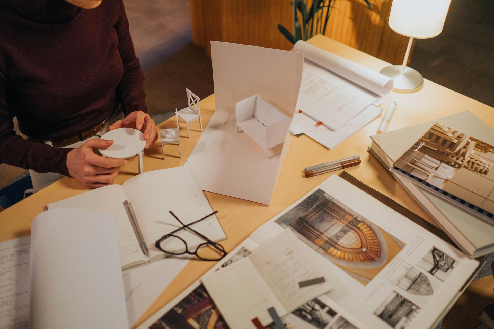 A woman is sitting at a table working on a project.