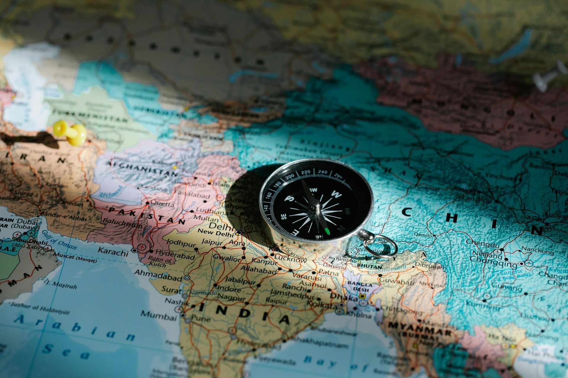 A compass is sitting on top of a map of india.