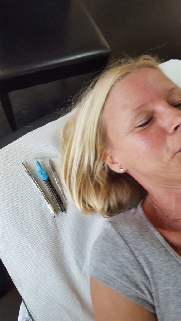 Eine Frau liegt mit geschlossenen Augen auf einem Bett.