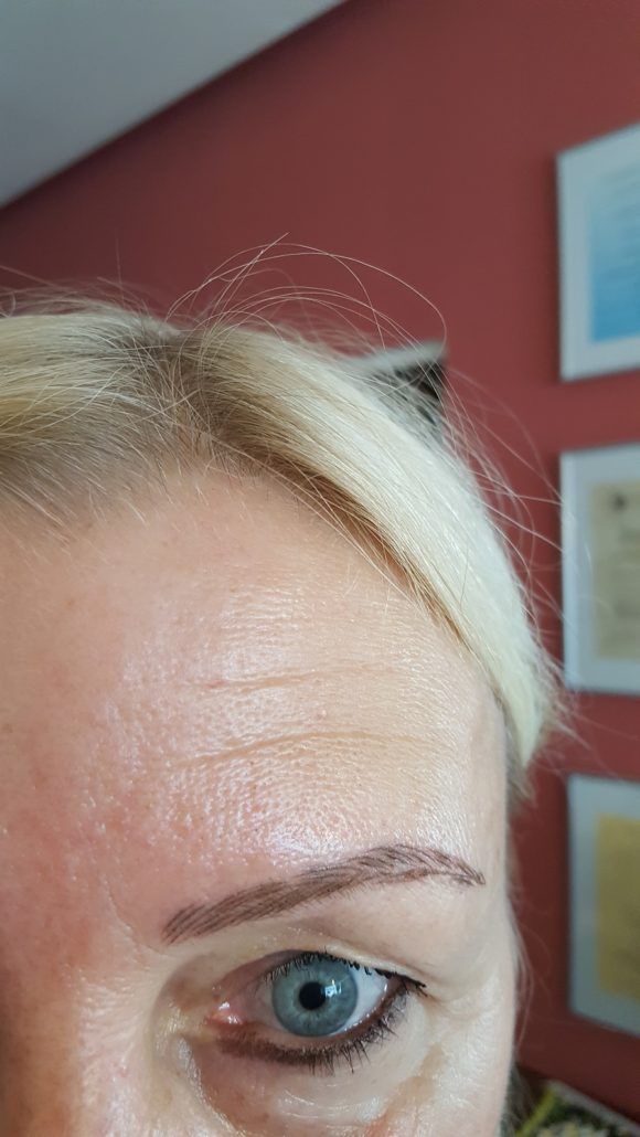 Eine Nahaufnahme des Gesichts einer Frau mit blauen Augen und blondem Haar.