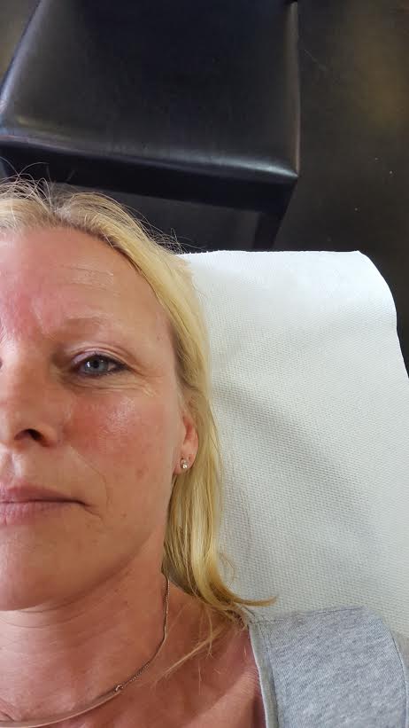 Eine Frau liegt mit einem weißen Handtuch auf dem Gesicht auf einem Tisch.