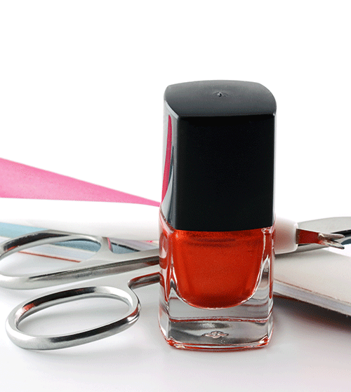 Eine Flasche Nagellack steht neben einer Schere