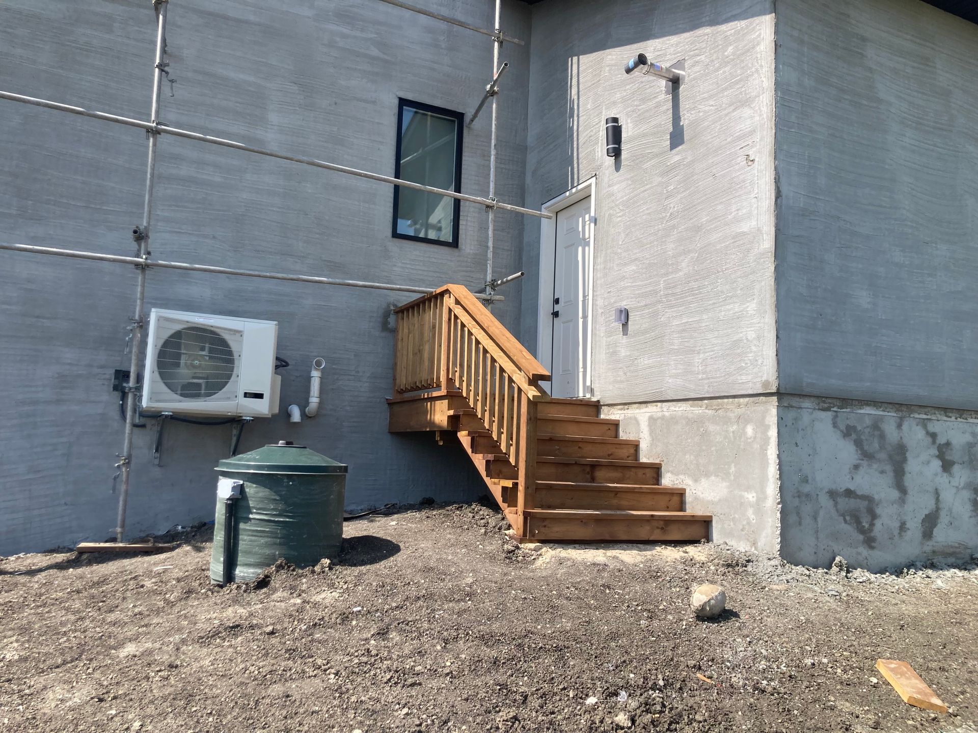 Two workers installing a wooden deck around a pool.