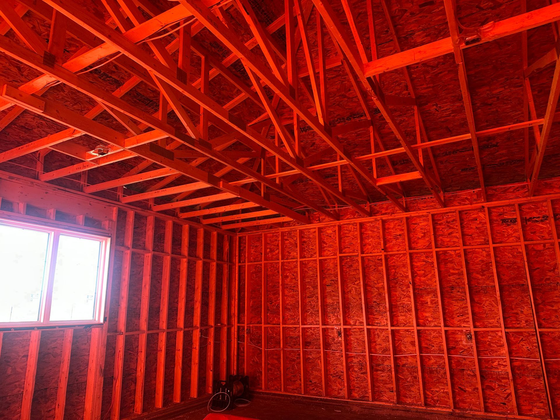 Interior view of a building under construction, showing a scaffold and partially finished drywall ceiling in a light green hue.