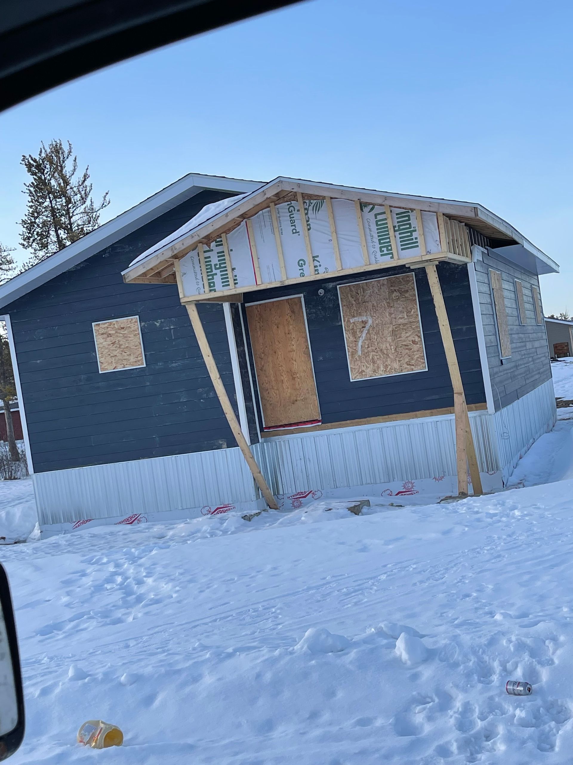 Owl perched on a gutter of a red-tiled roof.