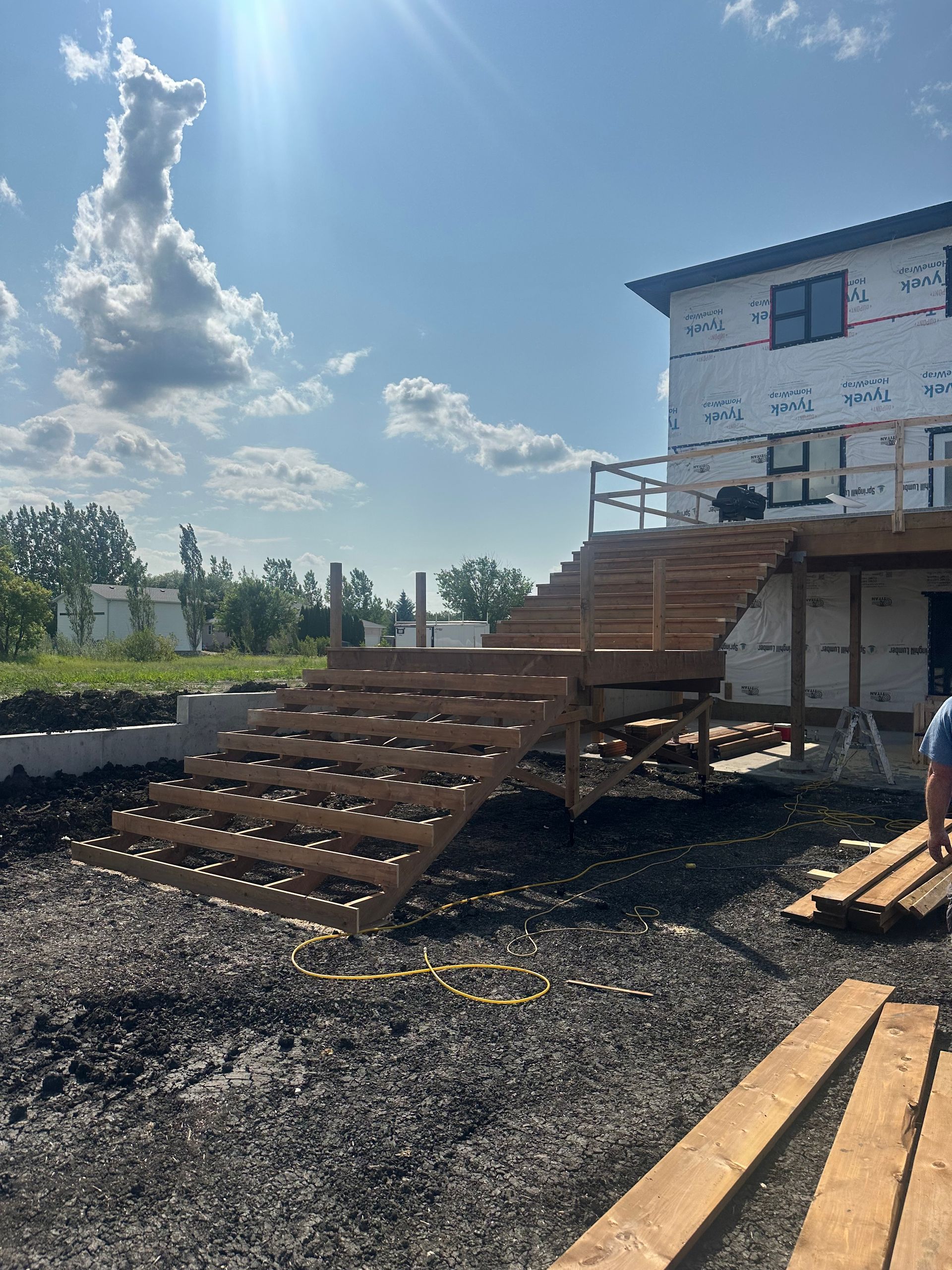 Corner of an old blue building with a brown wooden door, chipped paint, and a grassy area.