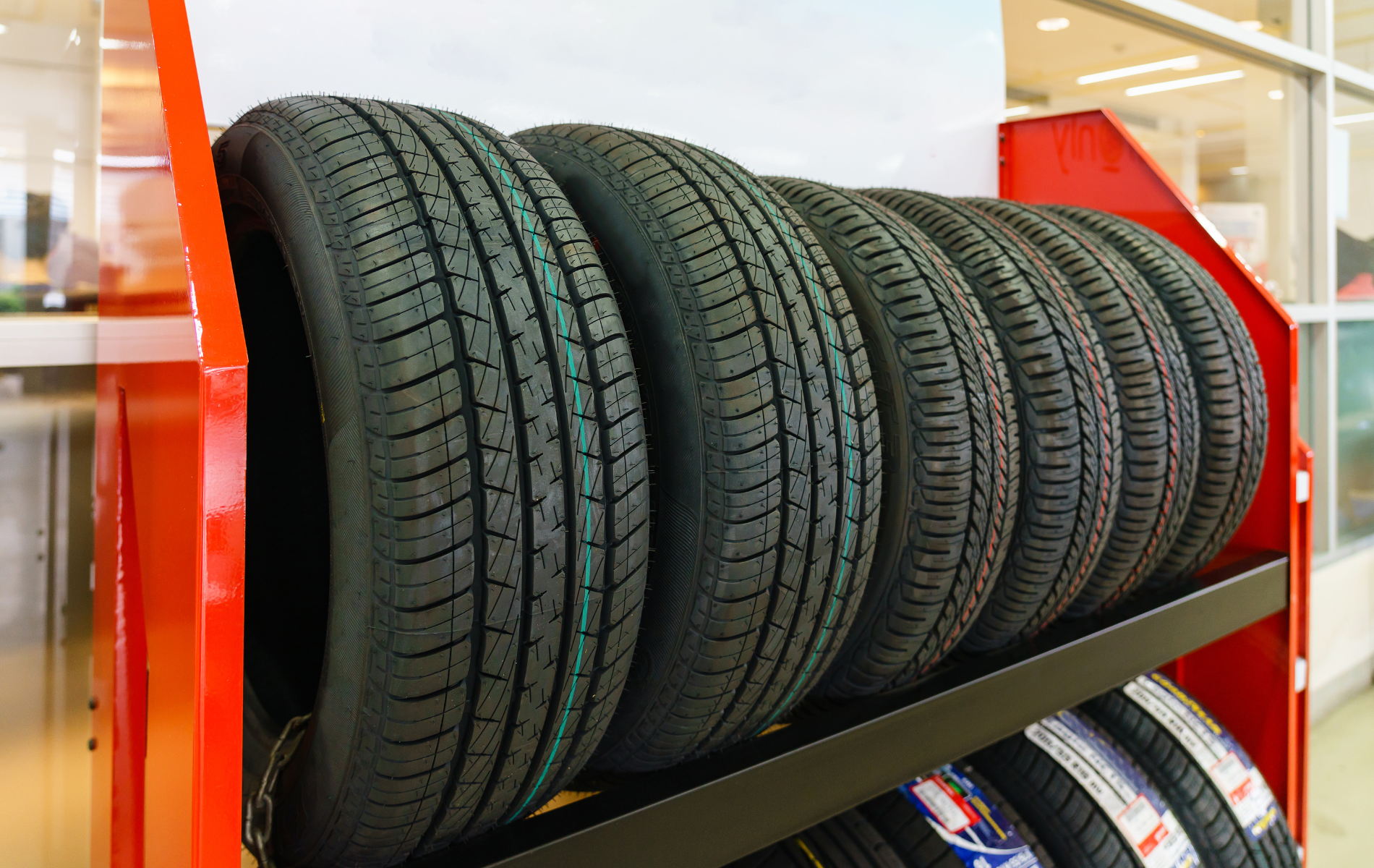 A stack of tires sitting on top of each other on a shelf in a store.