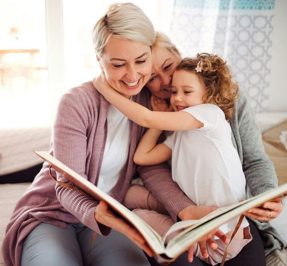 A woman is reading a book to a little girl