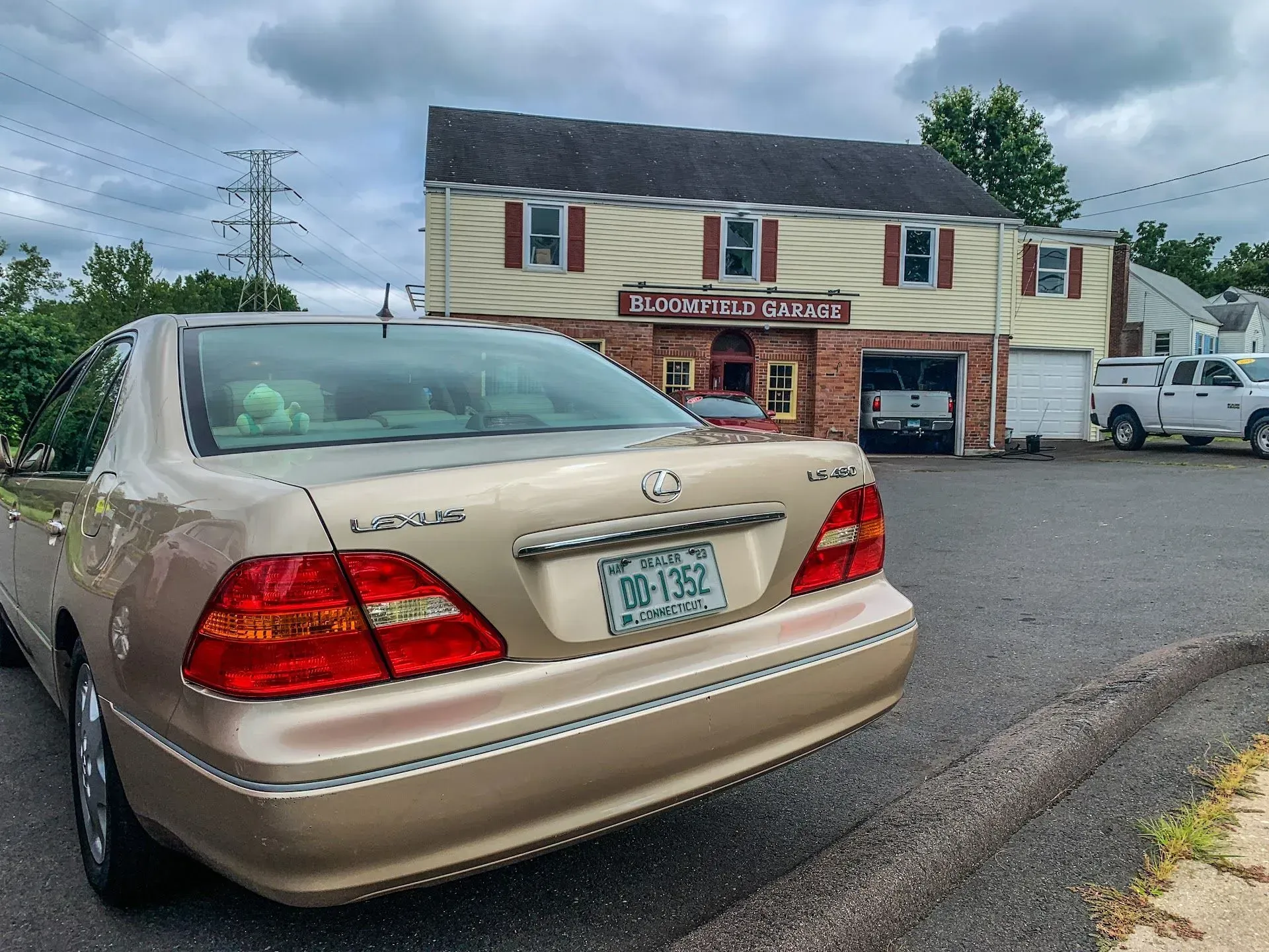 Tan sedan parked near a two-story building labeled
