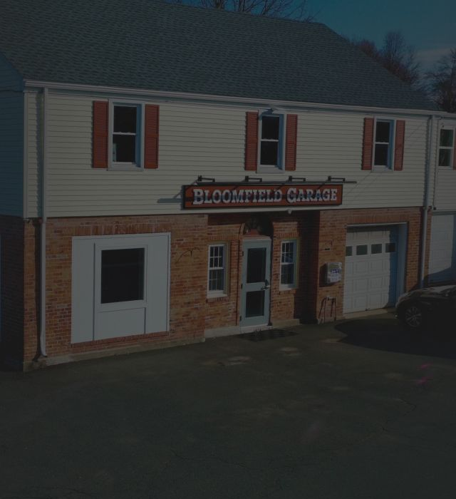 Two-story brick building with red shutters. Sign reads 