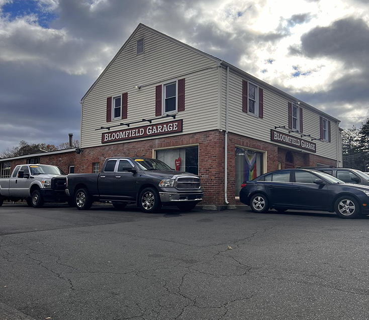 Bloomfield Garage building with vehicles parked in front on an overcast day. | Bloomfield Garage