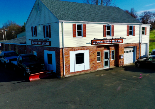 Two-story brick building: Beechfield Garage with snow plow truck. | Bloomfield Garage