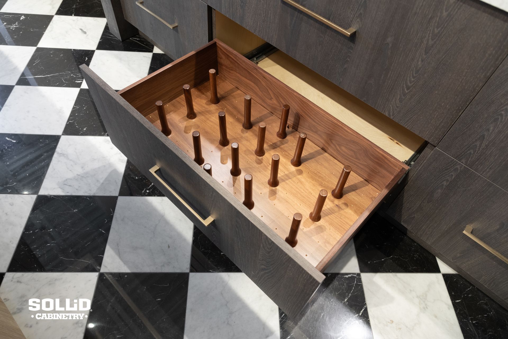 A drawer in a kitchen with a checkered floor