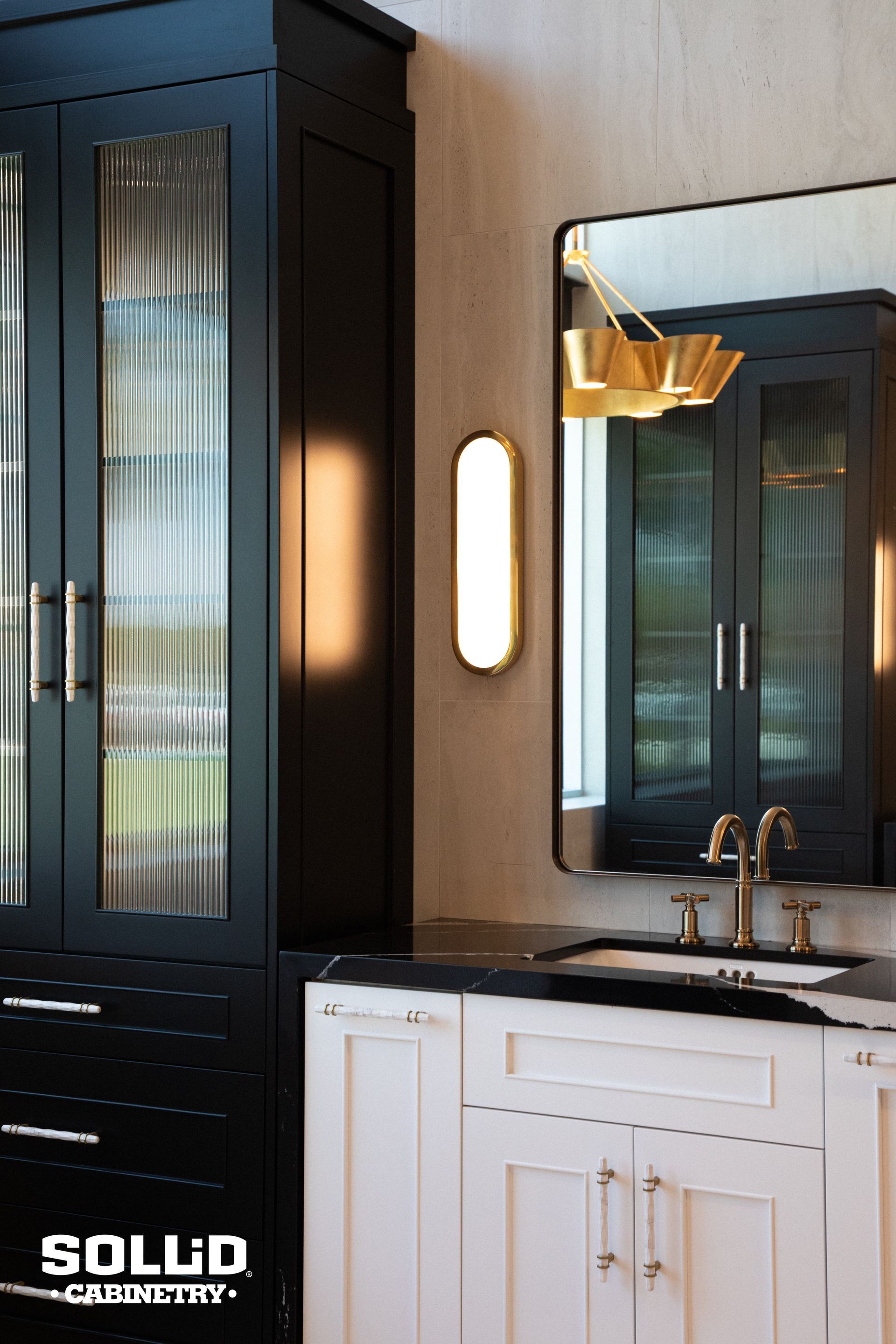 A bathroom with black cabinets , white cabinets , a sink and a mirror.
