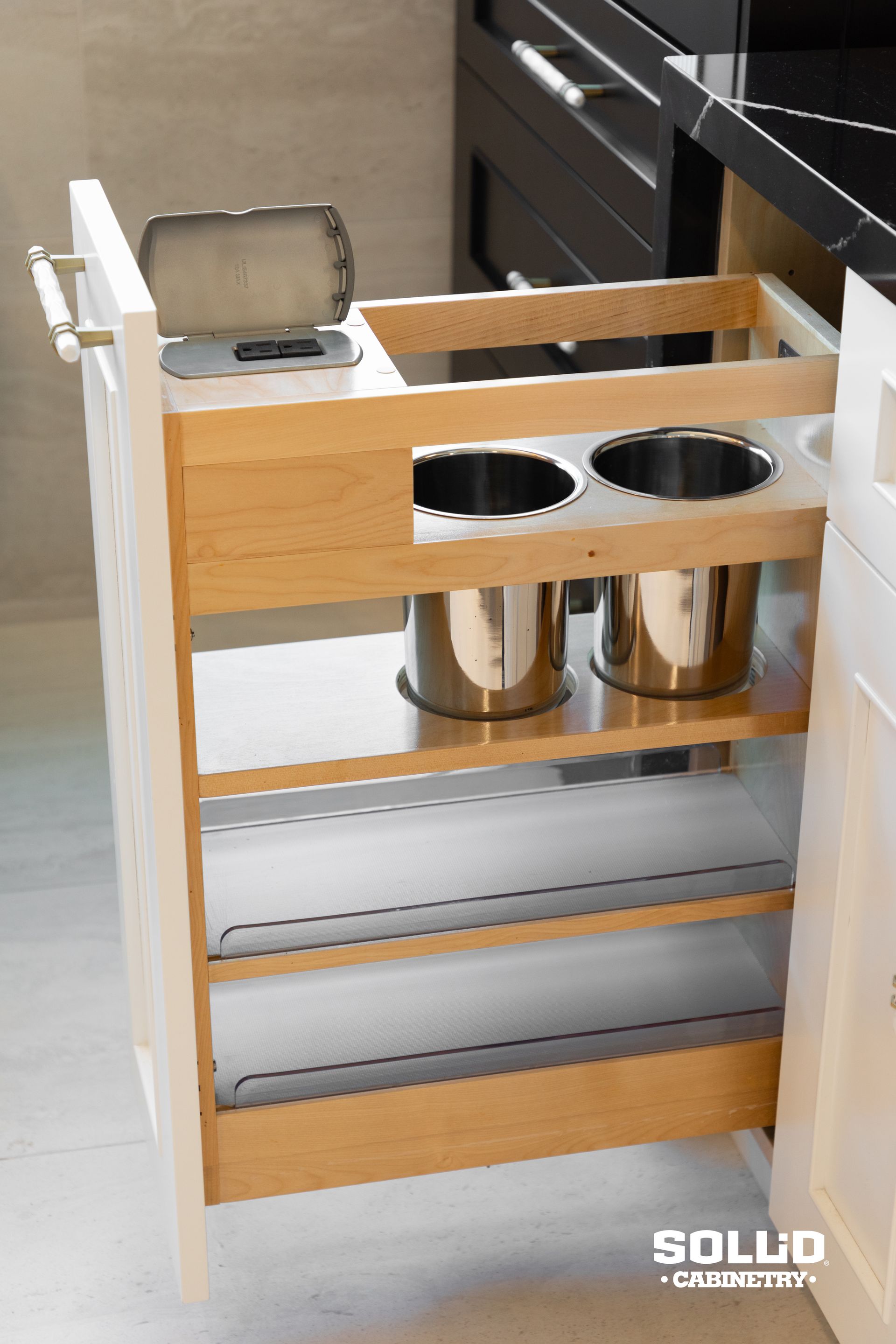 A kitchen drawer with two stainless steel buckets in it.