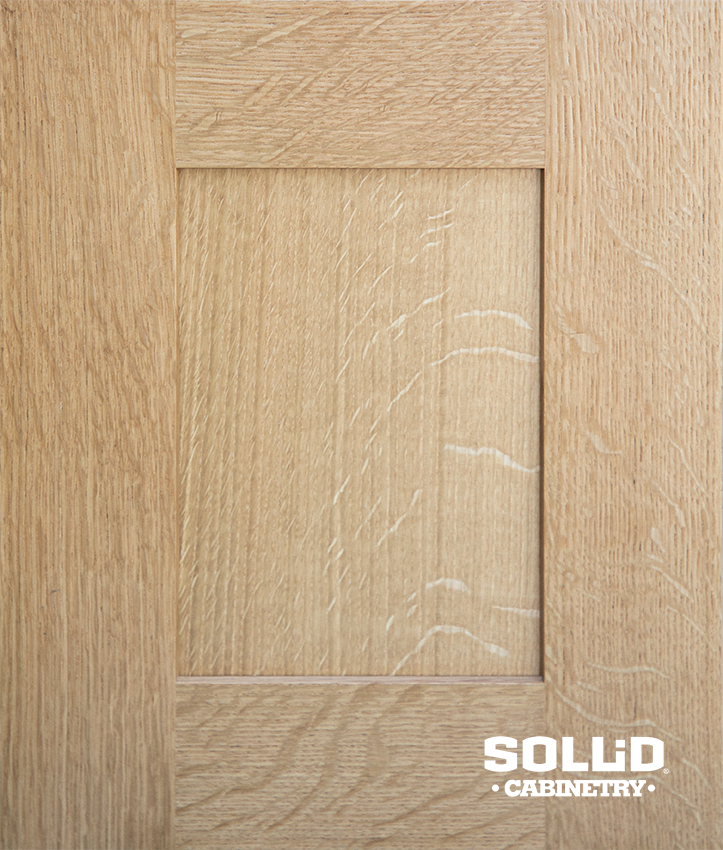 A close up of a wooden cabinet door with a square hole in the middle.