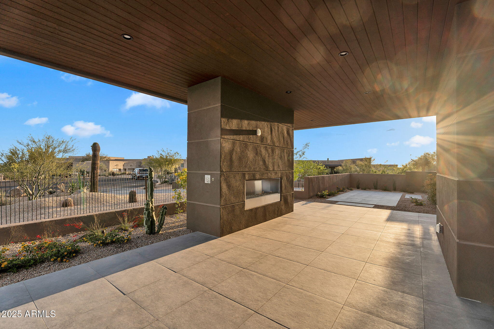 A patio with a fireplace and a wooden ceiling.