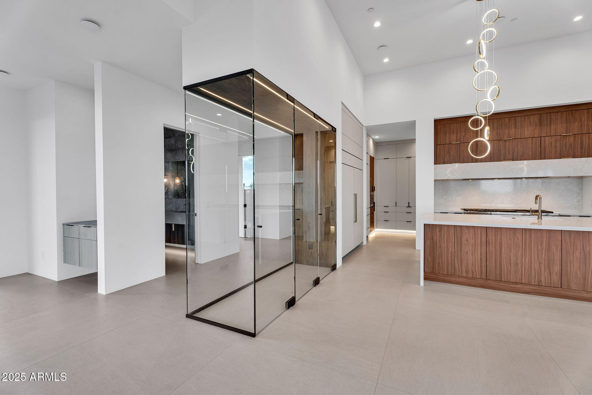 A large empty room with a glass wall and wooden cabinets.