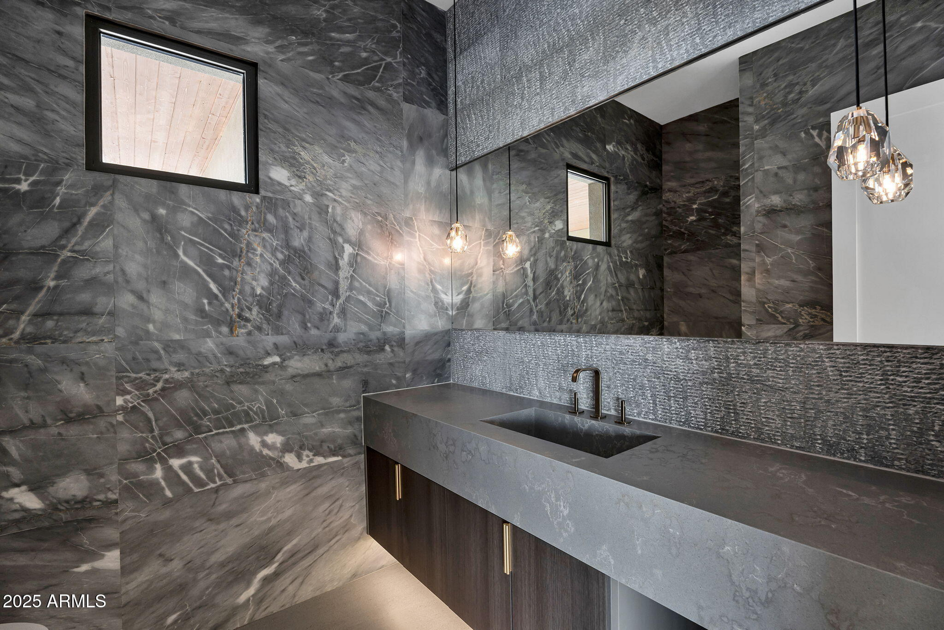 A bathroom with a sink and a large mirror.