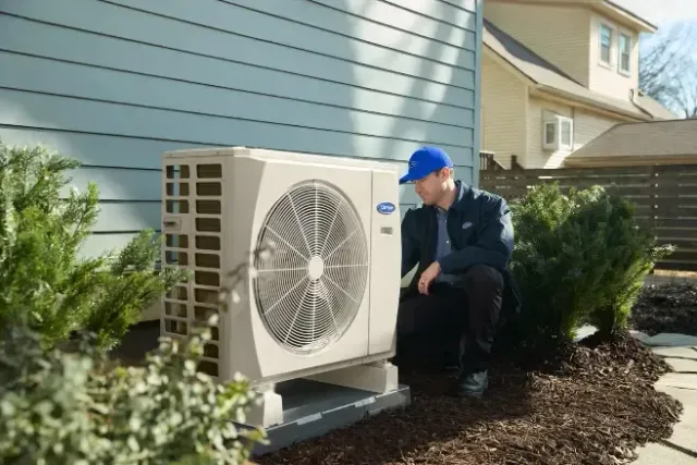 HVAC service gauges and a digital meter connected to copper refrigerant lines on an outdoor unit