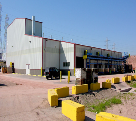 A large white building with a black suv parked in front of it
