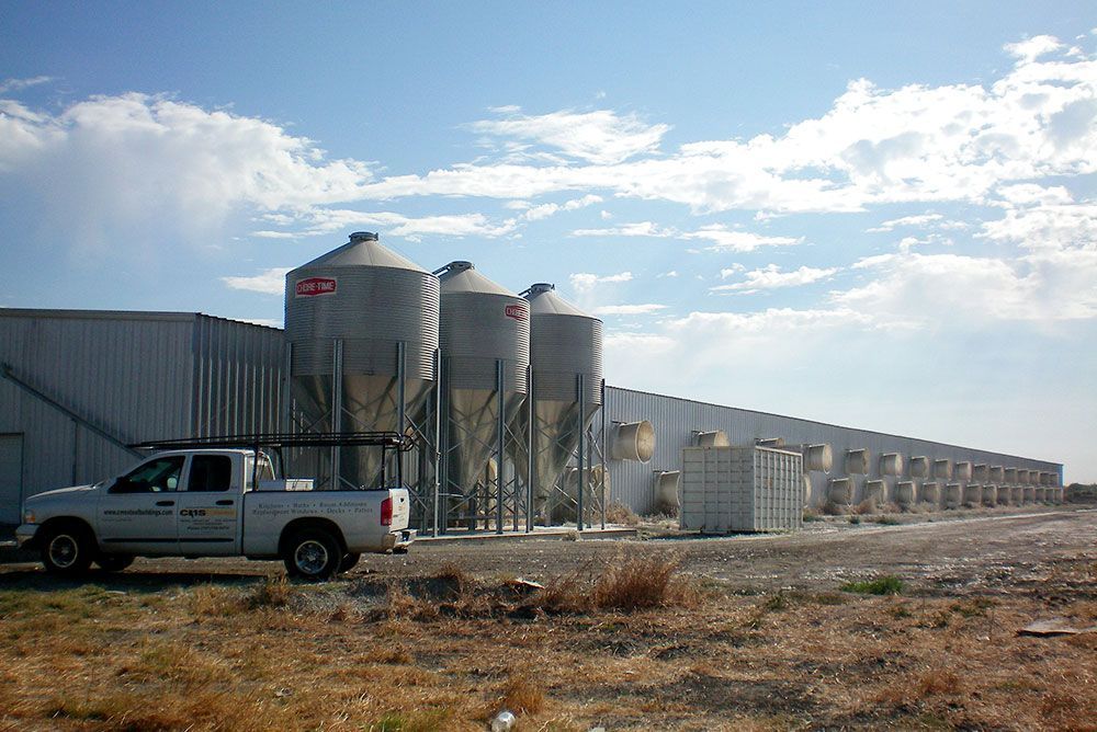 A white truck is parked in front of a large building.