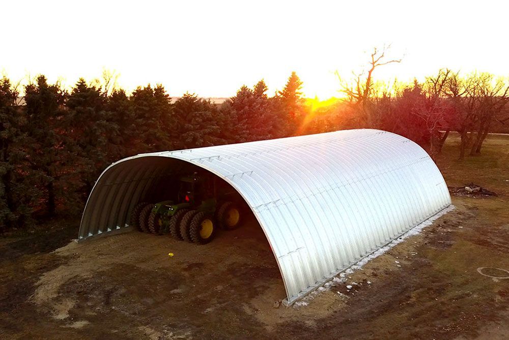A john deere tractor is parked under a metal structure