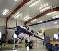 A small airplane is parked inside of a hangar.