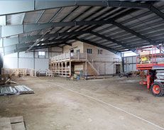 A large warehouse with a tractor parked inside of it.