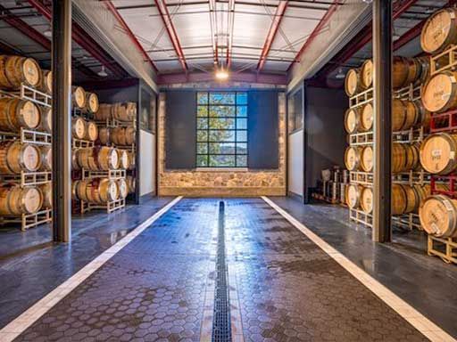 A large warehouse filled with lots of barrels and a window.