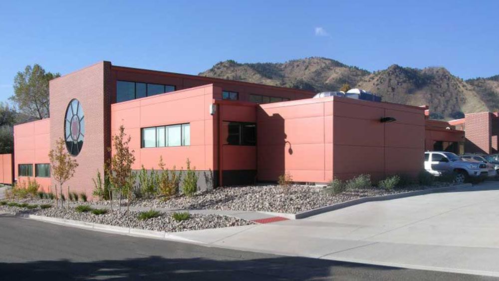 A large red building with mountains in the background