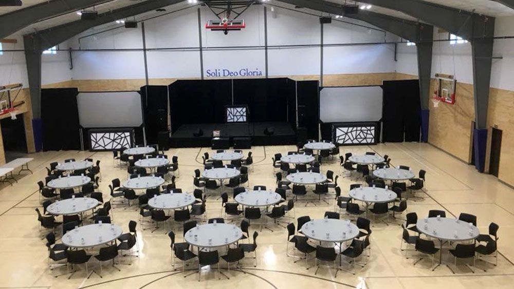 A large gym with tables and chairs set up for a party.